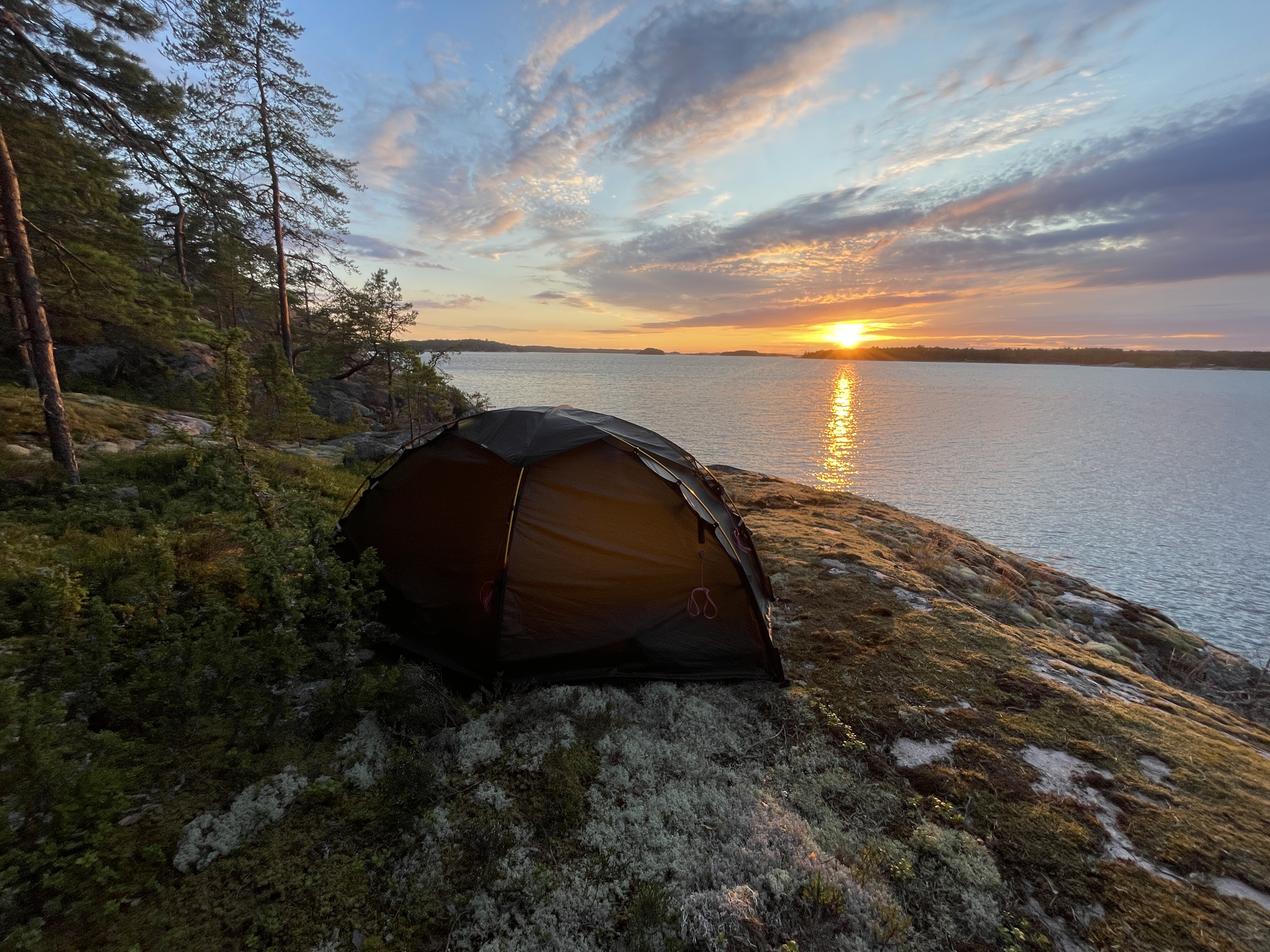 Bild på tält och solnedgång.